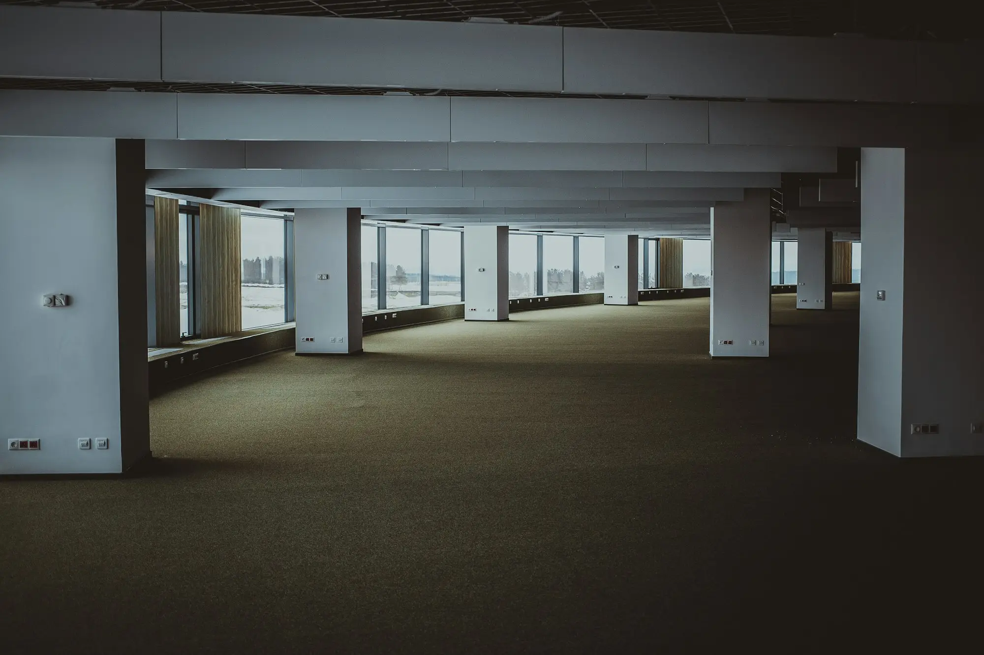 Owner measuring an empty, light-filled shop tenancy before signing the lease